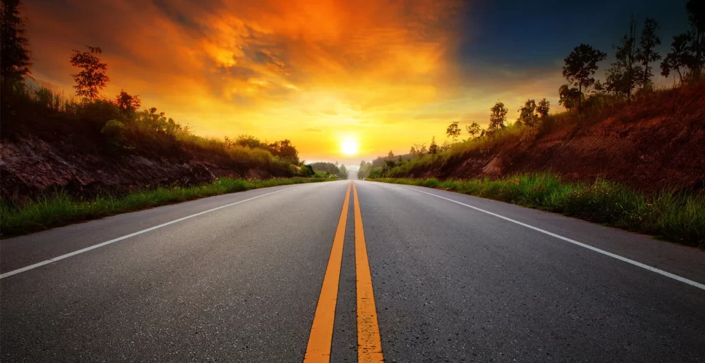 Open road leading toward the horizon at sunset